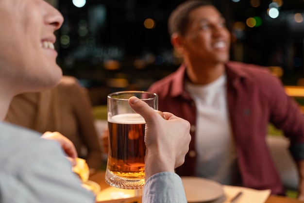 Zdjęcie close-up człowiek w pubie z piwem