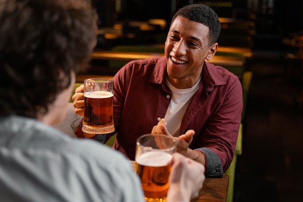 Zdjęcie close-up mężczyzn w pubie z piwem