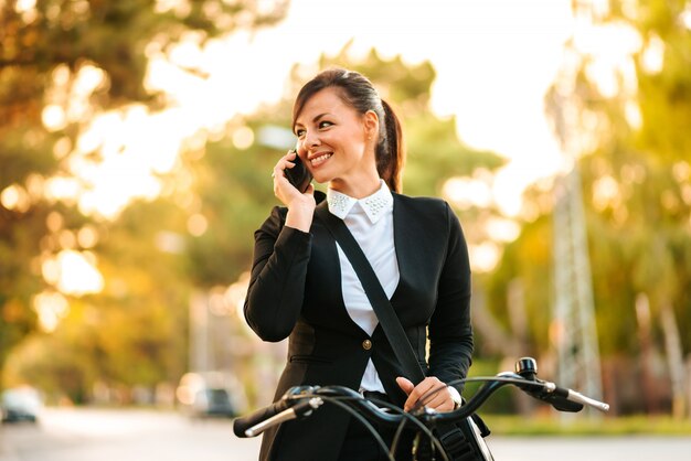 Close-up Obraz Piękna Bizneswoman Rozmawia Przez Telefon Podczas Jazdy Na Rowerze.