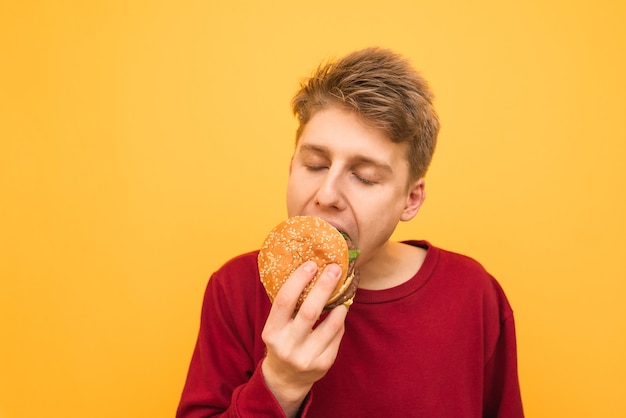 Close-up Portret Młodego Mężczyzny W Ubranie Gryzie Burgera