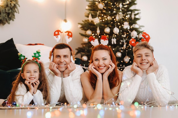 Close-up portret szczęśliwej rodziny leżącej w pobliżu choinki z okazji święta.