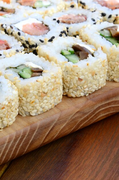 Close-up z wielu rolek sushi z różnymi nadzieniami leżą na drewnianej powierzchni