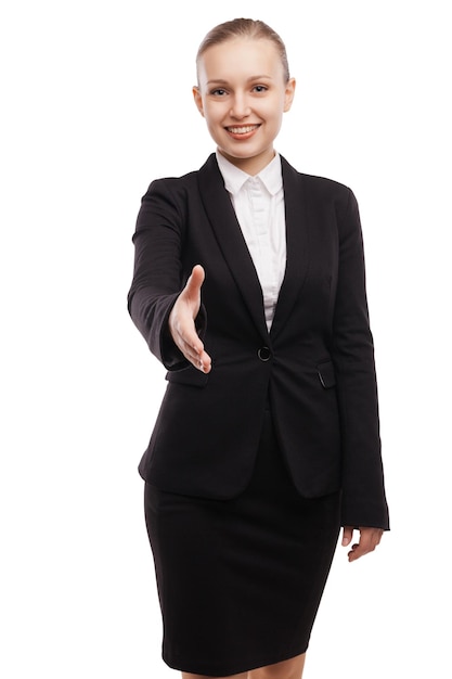 Closeupof ufny młody bizneswoman w garniturze wyciągający rękę do potrząsania i uśmiechania się stojąc na białym tle
