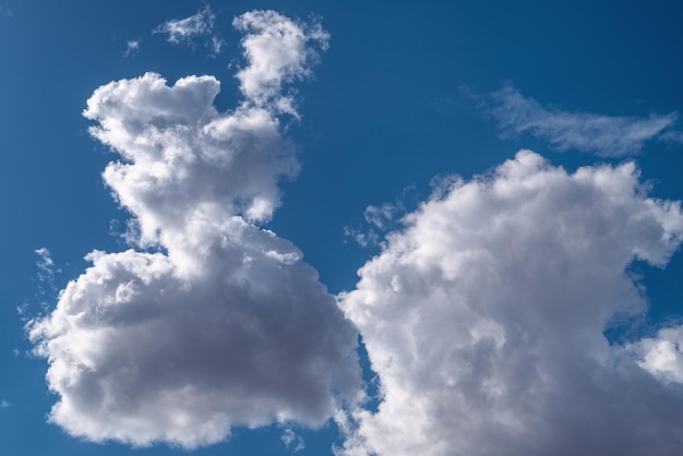 Cloudscape dużych białych i szarych chmur cumulus na jasnym niebieskim niebie