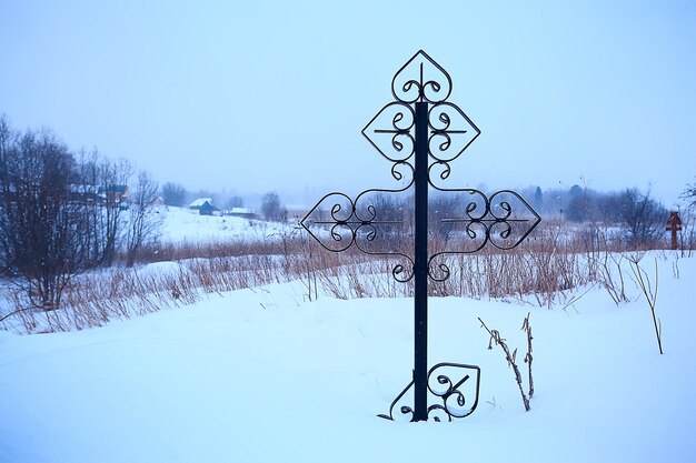 Zdjęcie cmentarz zimowy krzyż / smutek samotności koncepcji, krzyż w zimowym krajobrazie