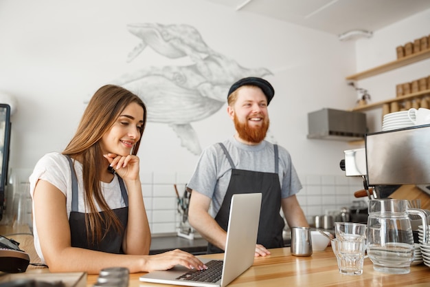 Coffee Business Concept szczęśliwa młoda para właścicieli małych kawiarni pracujących i planujących na laptopie