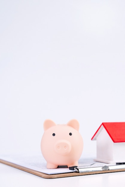 Concpet finansowy - Skarbonka, piękny czerwony biały drewniany dom model na białym tle, oszczędzając pieniądze na zakup ubezpieczenia, bliska, kopia miejsca.