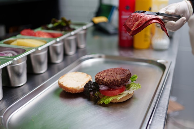 Zdjęcie cook przygotowuje wegańskiego burgera w swojej restauracji