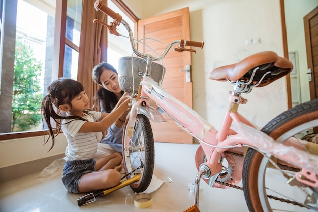 Córka i matka mocują śruby pod swoim nowym koszykiem rowerowym