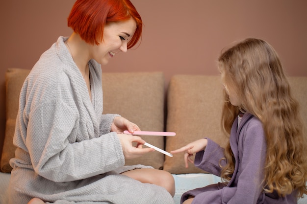 Córka Sprawia, że Mama Robi Manicure W Domu Na łóżku