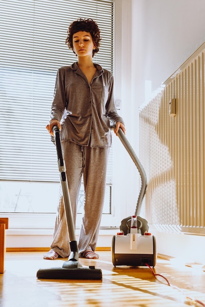 Córka sprząta mieszkanie, wykonuje prace domowe