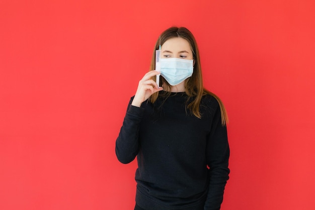 COVID19 Pandemiczny koronawirus Młoda dziewczyna na czerwonym tle maska ochronna trzymająca strzykawkę C