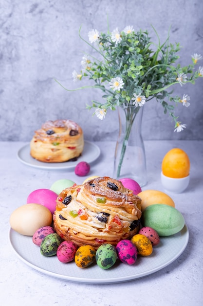 Zdjęcie craffin (cruffin) z rodzynkami, orzechami i owocami kandyzowanymi. chleb wielkanocny kulich i pisanki. ferie wielkanocne. zbliżenie.