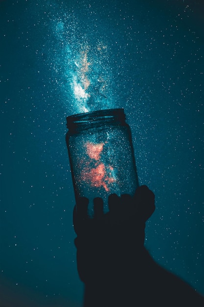 creative_photo_of_person_holding_glass_mason_jar_under_a_starry_sky