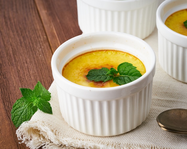 Crema catalana, hiszpański deser na brązowym drewnianym stole