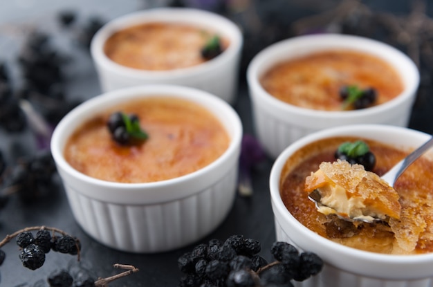 Creme brulee w białej misce ze skórką cukrową. Fotografia studyjna. stylu country.