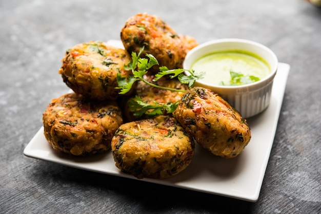 Zdjęcie crispy corn tikki, pakora lub pakoda lub pasztecik znany również jako kotlet. podawany z zielonym chutneyem. selektywne skupienie