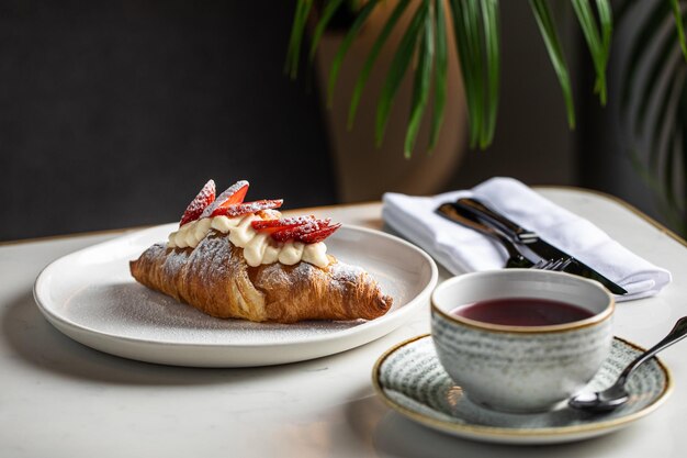 Croissant Chleb i herbata Świeże słodkie rogaliki z masłem i śniadanie z filiżanką herbaty