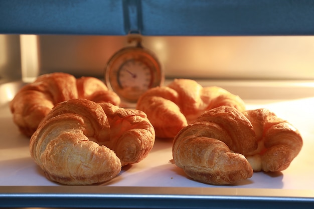 Croissant ser w piekarniku z ciepłymi światłami piekarnika tło.