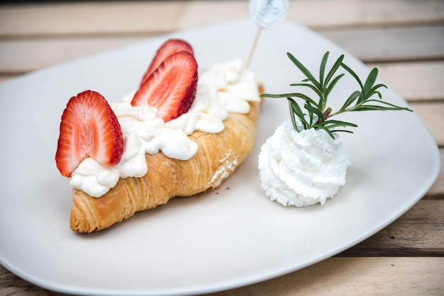 Zdjęcie croissant truskawkowo-śmietanowy na talerzu