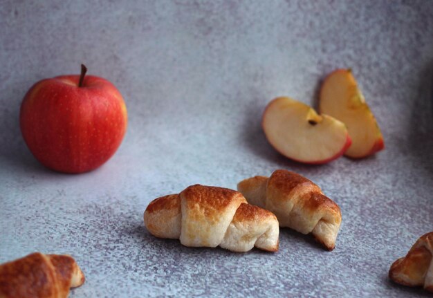 Croissant z ciasta francuskiego z jabłkiem na liliowym tle. Zdjęcie wysokiej jakości