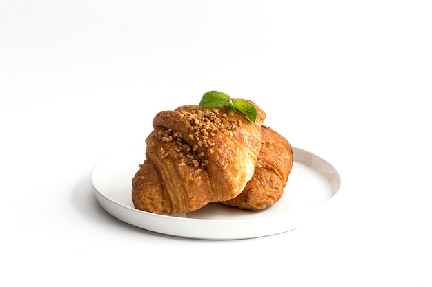 Croissant z migdałami na białym tle