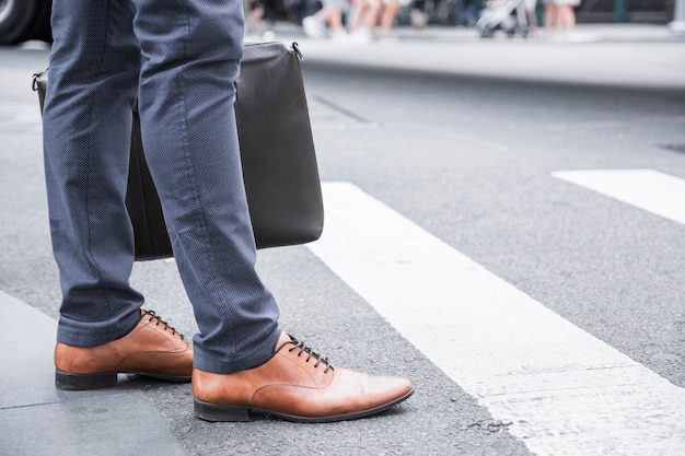 Zdjęcie crop biznesmen stoi blisko crosswalk