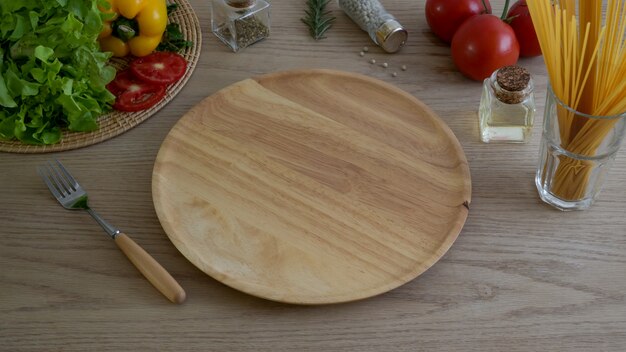 Cropped strzał kuchenny stół z warzywami na drewnianych naczyniach i składnikach
