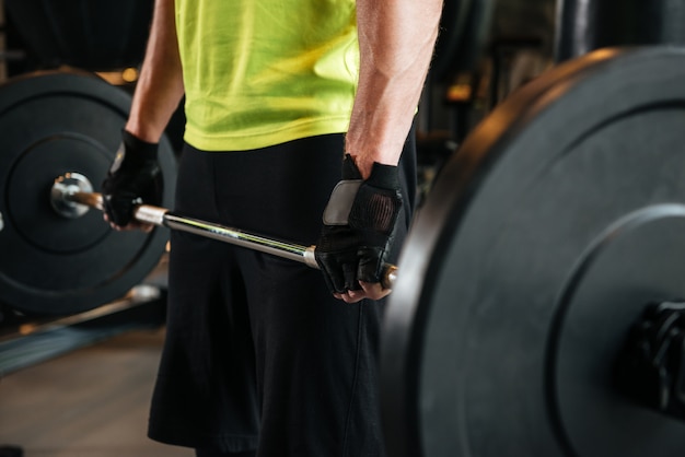 Cropped wizerunek sportowiec trzyma ciężkiego barbell