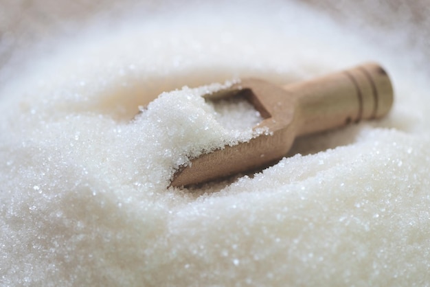 Cukier na drewnianej szufelce cukier biały do żywności i słodyczy kupa cukierków deserowych ze słodkiego cukru krystalicznego granulowanego