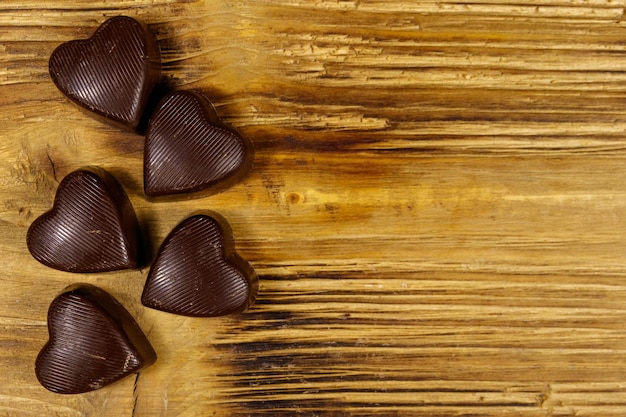 Cukierki czekoladowe w kształcie serca na drewnianym tle Widok z góry kopia przestrzeń Koncepcja Walentynki