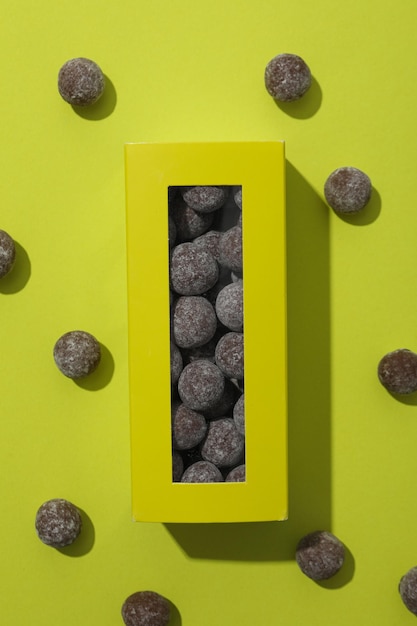 Cukierki czekoladowe w pudełku i na zielonym tle, widok z góry