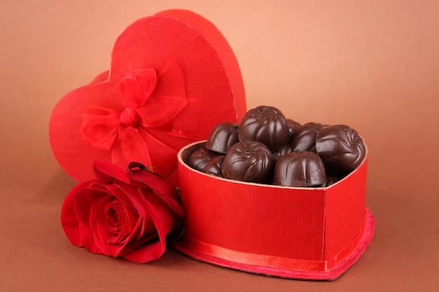 Cukierki czekoladowe w pudełku prezentowym, na brązowym tle