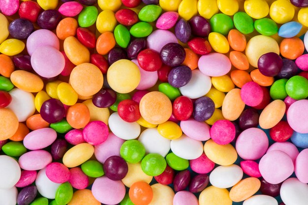 Cukierki Skittles na kolorowym stole kolorowe słodkie cukierki