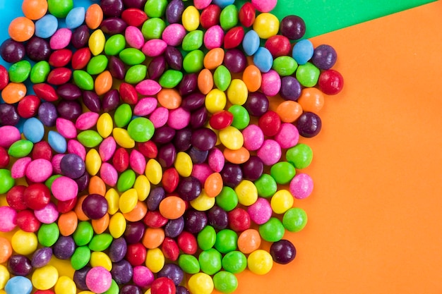 Cukierki Skittles na kolorowym stole kolorowe słodkie cukierki