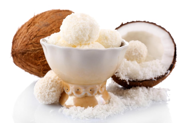 Cukierki w płatkach kokosowych i świeży kokos na białym tle