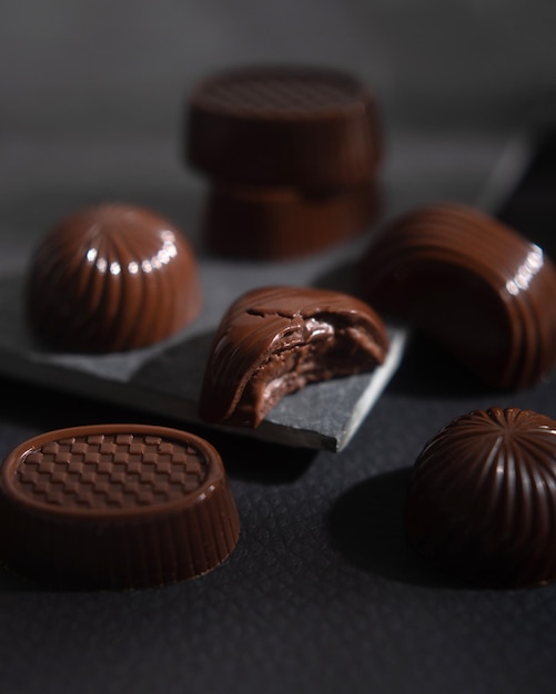 Cukierki z ciemnej gorzkiej czekolady w pudełku. Słodki deser to słodycze. Luksusowy asortyment słodyczy