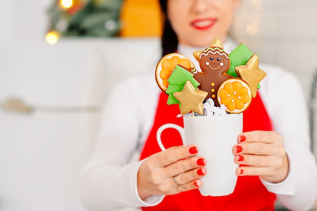 Zdjęcie cukiernia dziewczyna trzyma świąteczne ciasteczka ze świątecznym wystrojem
