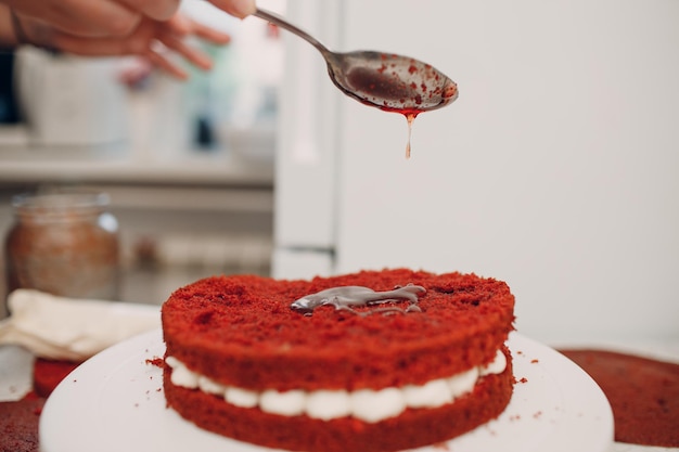 Cukiernik robi pyszne czerwone aksamitne ciasto Gotowanie i dekorowanie deseru