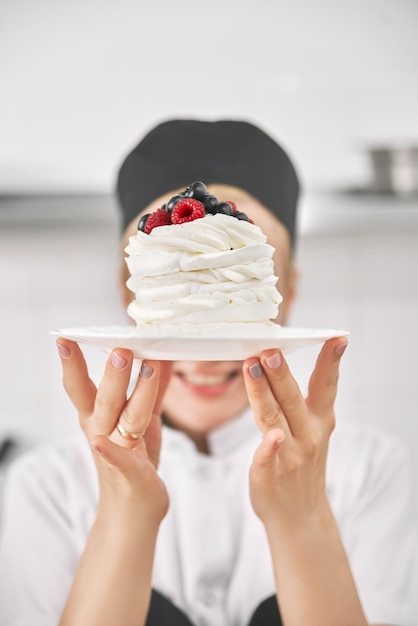 Cukiernik W Mundurze Trzyma W Rękach Deser Pavlova Demonstruje W Kuchni