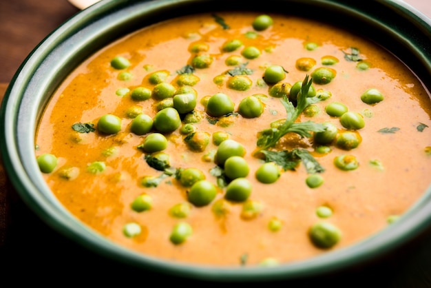 Curry z zielonego groszku lub Matar masala podawane w misce na nastrojowym tle. selektywne skupienie