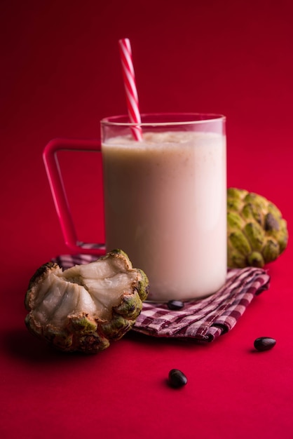 Custard Apple Lub Sitafal Milk Shake Podawane W Szklance Z Całymi Owocami Na Nastrojowym Tle. Selektywne Skupienie