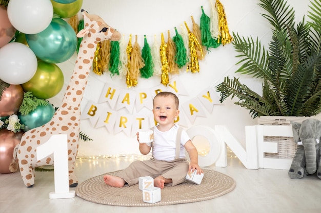 Cute baby boy kid świętuje swoje pierwsze urodziny na tle jasnych kolorowych balonów i świątecznych rekwizytów pierwsze wakacje dla dzieci