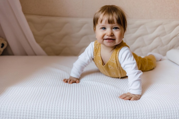 Cute baby boy leżącego na białej kartce w domu Chłopiec siedzi na łóżku