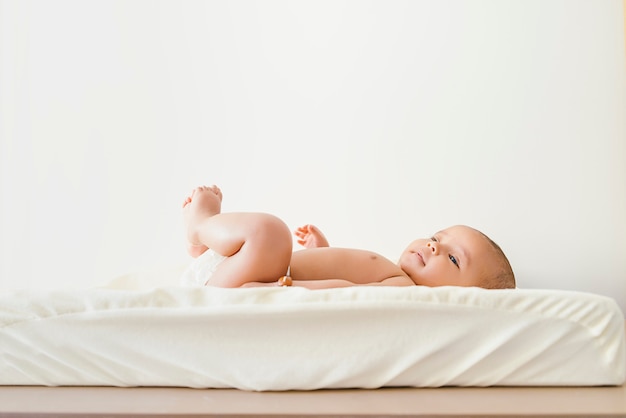 Cute Baby Girl leżącego w zmieniacz niemowląt.