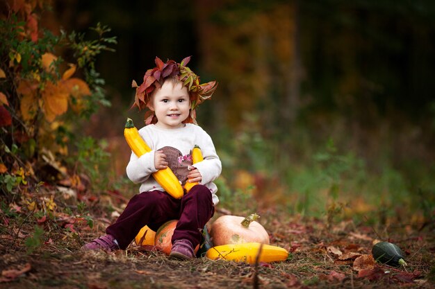 Cute dziewczynka bawi się szpiku warzyw w parku jesień. Jesienne zajęcia dla dzieci. Halloween i Święto Dziękczynienia zabawa dla rodziny. Skopiuj miejsce