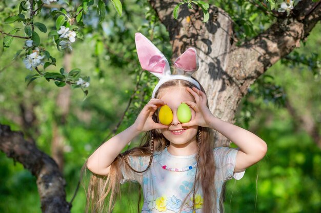 Cute Girl Z Uszami Królika W Dniu Wielkanocy Dziewczyna Goni Jaja Wielkanocne W Ogrodzie