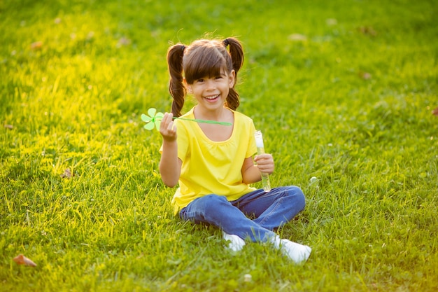 Cute little Indian girl lato na trawniku dmuchanie baniek mydlanych