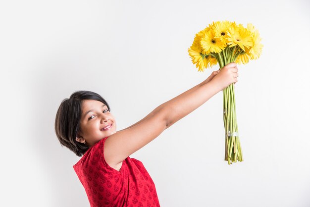 Cute Little Indian Girl Trzyma Kilka Lub Bukiet świeżych żółtych Kwiatów Gerbera. Pojedynczo Na Białym Tle