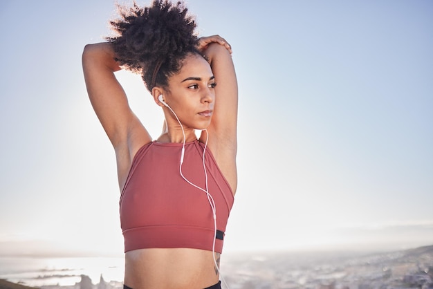 Ćwiczenia fitness i czarna kobieta rozciągająca się i słuchająca muzyki przez słuchawki na plaży na trening i trening Model sportowy na świeżym powietrzu w naturze dla energii, zdrowia i dobrego samopoczucia